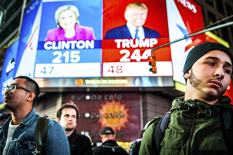 People watch election results at Times Square in New York, Nov. 9, 2016. Clinton has followed Al Gore as the second Democratic presidential candidate in modern history to be defeated by a Republican who earned fewer votes. Even President-elect Donald Trump, who won the electoral vote but lost the popular vote, called the system "a disaster for a democracy" in 2012. Now Trump thinks it is "genius." (File — George Etheredge/The New York Times)