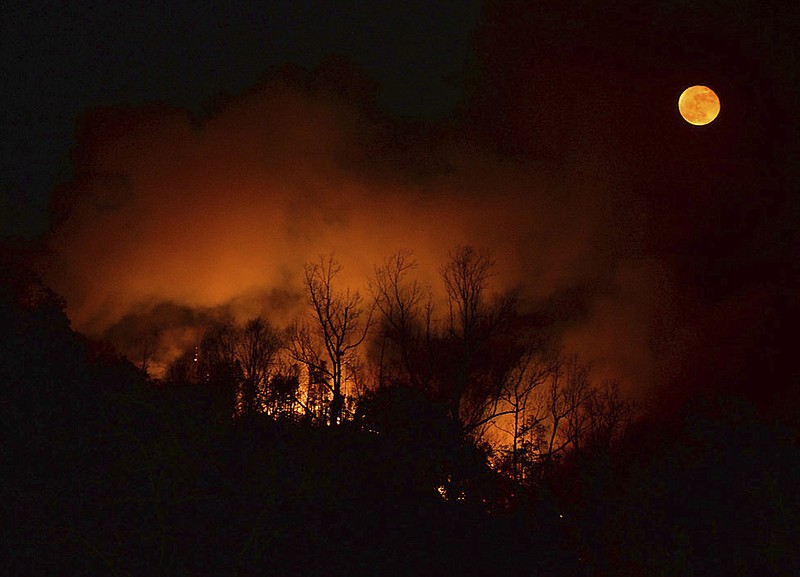 
              In this Tuesday, Nov. 15, 2016, photo, a wildfire burns as it approaches Bat Cave, N.C. Thick smoke has settled over a wide area of the southern Appalachians, where dozens of uncontrolled wildfires are burning through decades of leaf litter, and people breathe in tiny bits of the forest with every gulp of air. (Patrick Sullivan/The Times-News via AP)
            