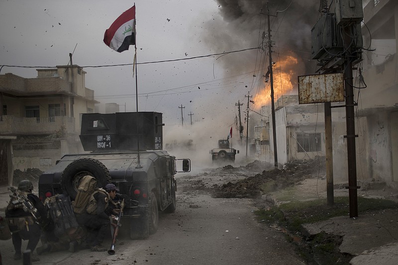 
              FILE - In this Wednesday, Nov. 16, 2016 file photo, a car bomb explodes next to Iraqi special forces armored vehicles as they advance towards Islamic State held territory in Mosul, Iraq. As the operation to retake Mosul enters its second month Iraqi forces are preparing for prolonged, grueling urban combat as they slow the tempo of their operation, advancing just a few hundred meters at a time. The individual tactics employed by IS mirror past fights with the group, but the sheer scale of IS defenses and counterattacks in Mosul has overwhelmed Iraq’s military.(AP Photo/Felipe Dana, File)
            