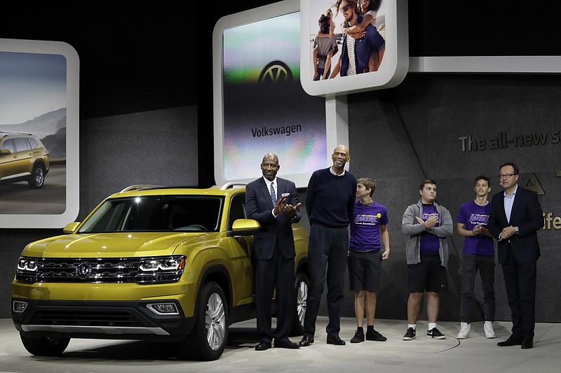 Former Los Angeles Lakers James Worthy, left, and Kareem Abdul-Jabbar, second from left, pose with the 2017 Volkswagen Atlas during the Los Angeles Auto Show in Los Angeles, Thursday, Nov. 17, 2016.
