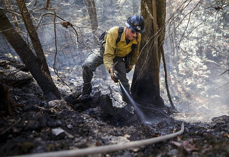 Firefighter Devin Delaney from St. Joseph, Missouri, sprays hot spots while battling a slop-over of the Rough Ridge wildfire in the Cohutta Wilderness of the Chattahoochee-Oconee National Forest on Friday, Nov. 18, 2016, near Chatsworth, Ga. The wildfire, which was started by lightning in mid-October, has burned in mostly wilderness areas.