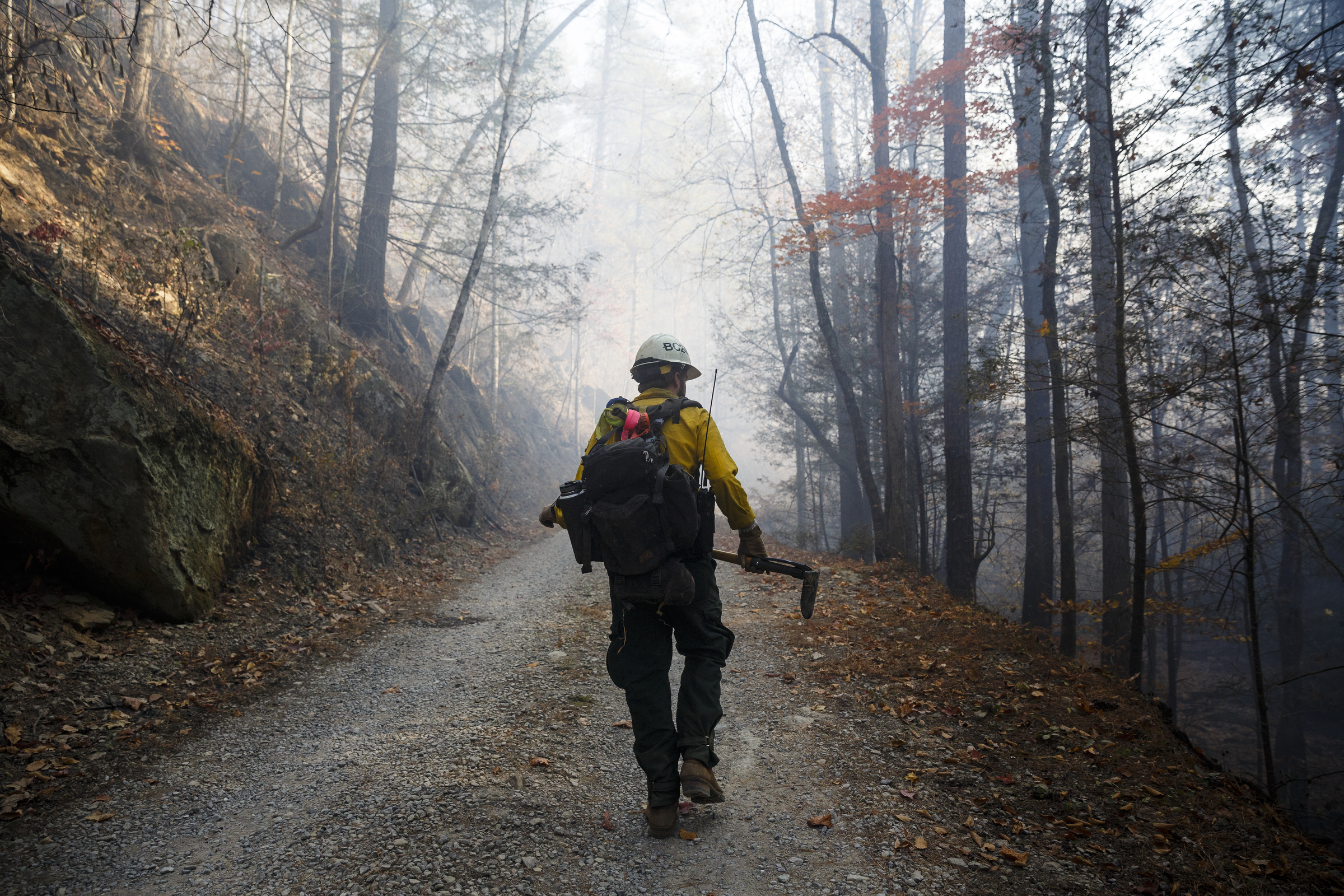 Firefighter Seth Mitchell from Los Angeles, California, walks along a road while monitoring a slop over of the Rough Ridge wildfire in the Cohutta Wilderness of the Chattahoochee-Oconee National Forest on Friday, Nov. 18, 2016, near Chatsworth, Ga. The wildfire, which was started by lightning in mid-October, has burned in mostly wilderness areas.