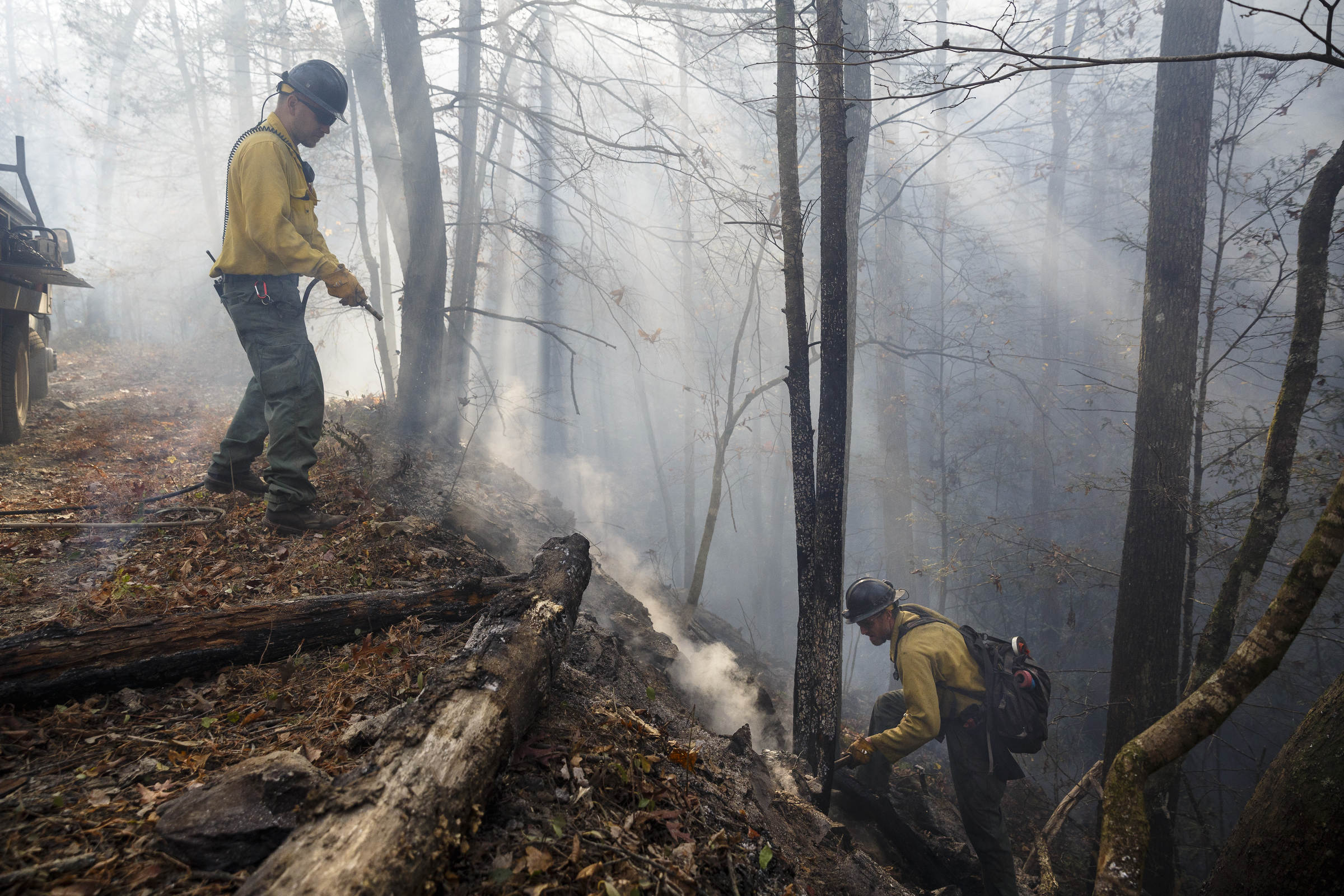 Firefighters Nate Huestis, left, and Devin Delaney with the Kansas Bureau of Indian Affairs use an engine to spray out hot spots while battling the Rough Ridge wildfire in the Cohutta Wilderness of the Chattahoochee-Oconee National Forest on Friday, Nov. 18, 2016, near Chatsworth, Ga. The wildfire, which was started by lightning in mid-October, has burned in mostly wilderness areas.