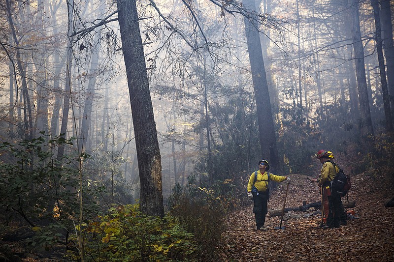 Firefighters from Puerto Rico monitor a fire line while battling the Rough Ridge wildfire in the Cohutta Wilderness of the Chattahoochee-Oconee National Forest on Friday, Nov. 18, 2016, near Chatsworth, Ga. The wildfire, which was started by lightning in mid-October, has burned in mostly wilderness areas.