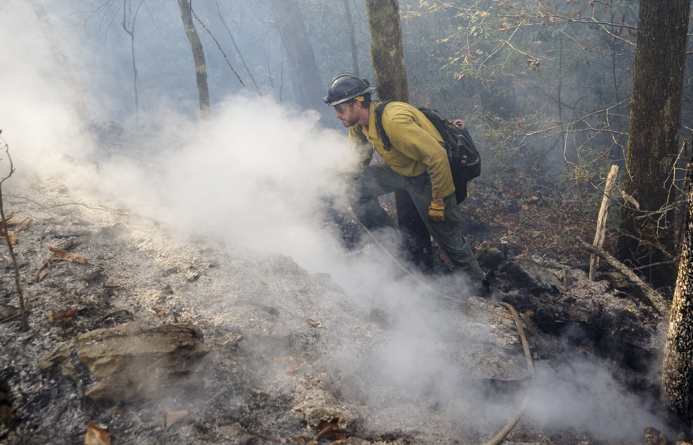 Firefighter Devin Delaney from St. Joseph, Missouri, works to put out hot spots in the ground while battling the Rough Ridge wildfire in the Cohutta Wilderness of the Chattahoochee-Oconee National Forest on Friday, Nov. 18, 2016, near Chatsworth, Ga. The wildfire, which was started by lightning in mid-October, has burned in mostly wilderness areas.