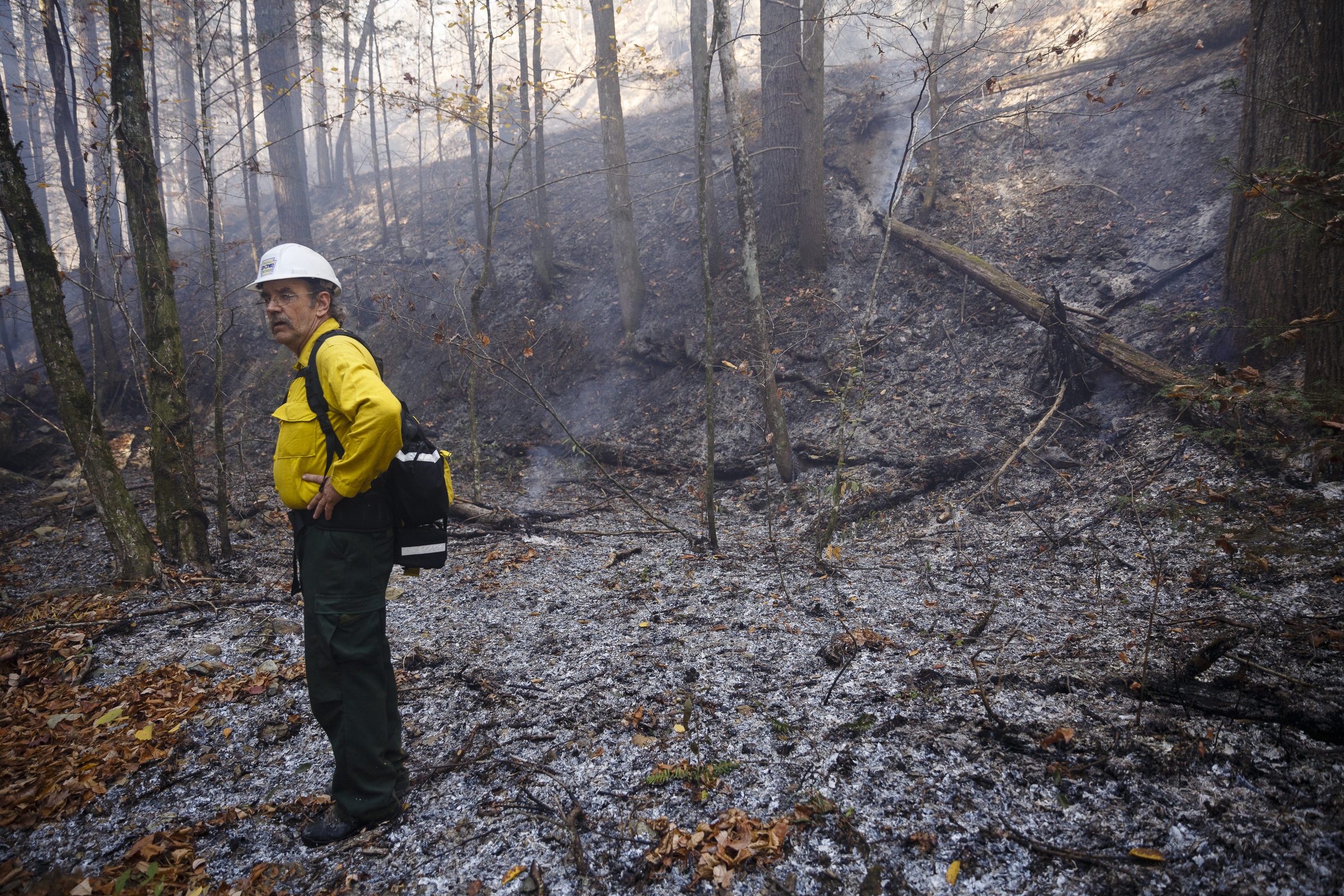 Safety officer Ray Miller, from Pennsylvania, stands in a section of brush burned by a slop-over as firefighters battle the Rough Ridge wildfire in the Cohutta Wilderness of the Chattahoochee-Oconee National Forest on Friday, Nov. 18, 2016, near Chatsworth, Ga. The wildfire, which was started by lightning in mid-October, has burned in mostly wilderness areas.