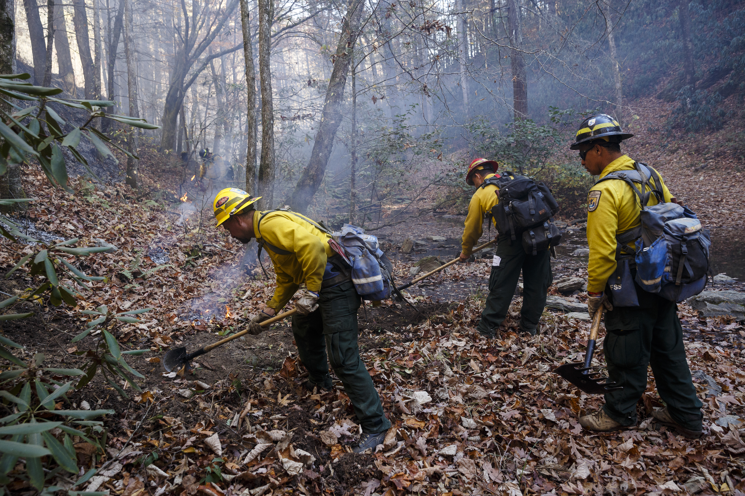 Firefighters Adalberto Vega, Luis Saez, and Julio Laboy, from left, from Puerto Rico, keep a fire line clear while battling a slop-over of the Rough Ridge wildfire in the Cohutta Wilderness of the Chattahoochee-Oconee National Forest on Friday, Nov. 18, 2016, near Chatsworth, Ga. The wildfire, which was started by lightning in mid-October, has burned in mostly wilderness areas.