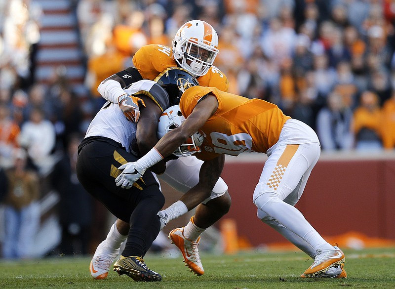 Tennessee defensive back Nigel Warrior (18) and linebacker Darrin Kirkland, Jr., tackle Missouri runningback Ish Witter during the Vols' home football game against the Missouri Tigers at Neyland Stadium on Saturday, Nov. 19, 2016, in Chattanooga, Tenn. Tennessee won their final home game of the season 63-37.