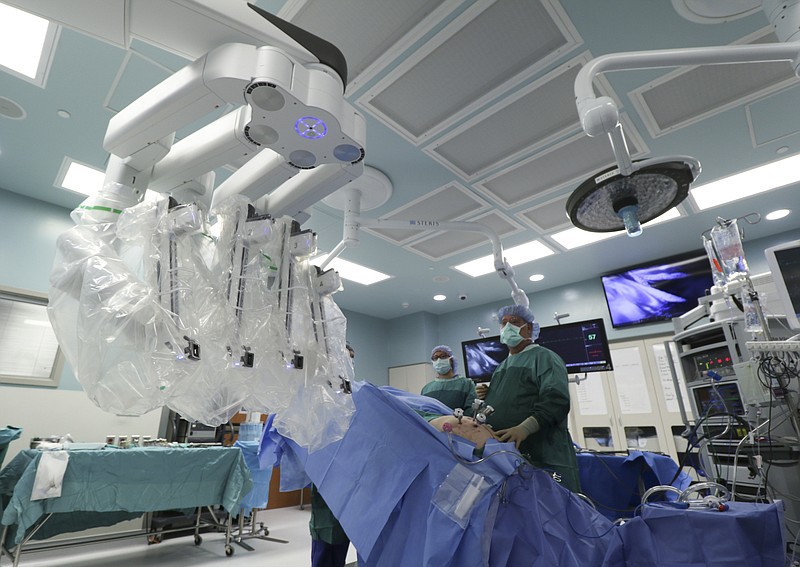 
              A team prepares to attach a da Vinci robot to a patient while performing a robotic assisted laparoscopic prostatectomy at CHI Memorial Hospital on Nov. 2, 2016 in Chattanooga, Tenn.   Area doctors say improvements in cameras, mobility and size are making the high-tech devices much more useful for surgeons in many more specialties than before. (Dan Henry/Chattanooga Times Free Press via AP)
            