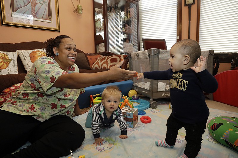 In this Thursday, Oct. 20, 2016, photo, Nancy Harvey, owner of Lil' Nancy's Primary Schoolhouse, left, cares for toddlers at her home, which has she has converted into a child care center, in Oakland, Calif. Most U.S. households are heading for a worse lifestyle in retirement than they had while they were working, because they simply aren't saving enough, experts say. Harvey, who has less than $2,000 saved despite her decades of work, plans to continue with real-estate classes in hopes that it can provide a second job.(AP Photo/Marcio Jose Sanchez)
