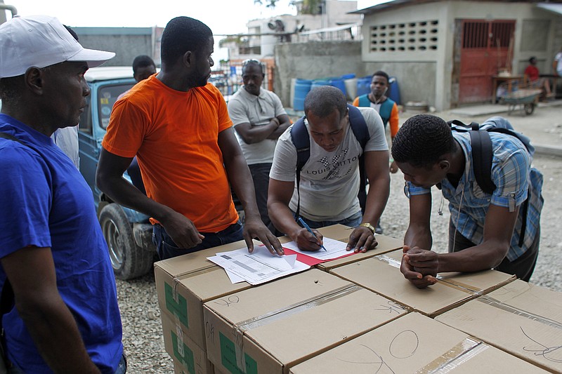 
              Workers count boxes of electoral material in a polling station in Port-au-Prince, Haiti, Saturday, Nov. 19, 2016. Sunday's voters will choose a president, with the top two finishers going to a Jan. 29 runoff, as well as senators and members of the Chamber of Deputies. (AP Photo/Ricardo Arduengo)
            