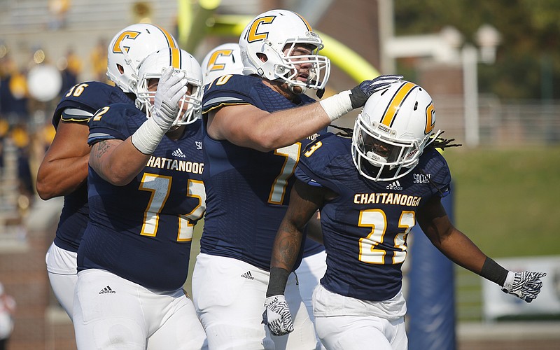 UTC offensive linemen congratulate running back Richardre Bagley, right, after a touchdown during the Mocs' game against Wofford at Finley Stadium earlier this month. UTC will be back there this week for a playoff game against Weber State.