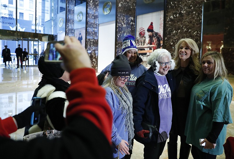 
              President-elect Donald Trump's campaign manager Kellyanne Conway poses with tourists for photographs in the lobby of Trump Tower in New York, Monday, Nov. 21, 2016. Welcome to Trump Tower. Upstairs, the President-elect is planning his administration. Downstairs it’s a full-on political carnival. Since Donald Trump’s stunning presidential victory, the celebrity businessman has largely been ensconced in his penthouse home at his 664-foot glass tower on Manhattan’s Fifth Avenue. But as he works, the political circus that has accompanied his spectacular rise unfolds in the building’s marble-floored, gold-plated public lobby before crowds of journalists, supporters and wide-eyed gawkers.  (AP Photo/Carolyn Kaster)
            