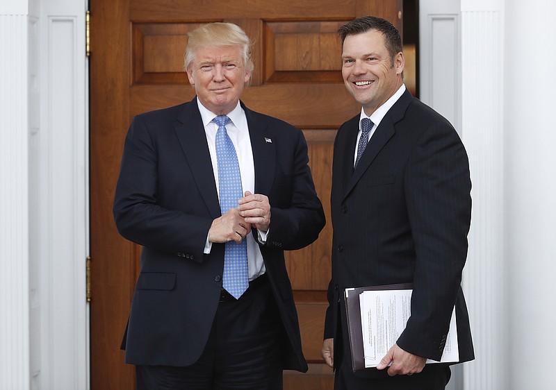 
              President-elect Donald Trump pauses pose for photographs as he greets Kansas Secretary of State, Kris Kobach, at the Trump National Golf Club Bedminster clubhouse, Sunday, Nov. 20, 2016, in Bedminster, N.J.. (AP Photo/Carolyn Kaster)
            