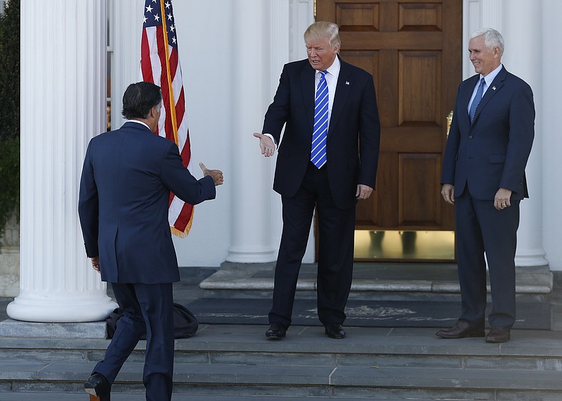 
              President-elect Donald Trump, center, and Vice President-elect Mike Pence, right, greet Mitt Romney, left, as he arrives at Trump National Golf Club Bedminster clubhouse in Bedminster, N.J., Saturday, Nov. 19, 2016. Dozens of Republican foreign policy experts, business leaders and elected officials broke party ranks to come out against Trump during the contentious presidential race.  Now, they're facing a difficult choice: Get on the Trump train or stand by and watch it leave from the station.  (AP Photo/Carolyn Kaster)
            