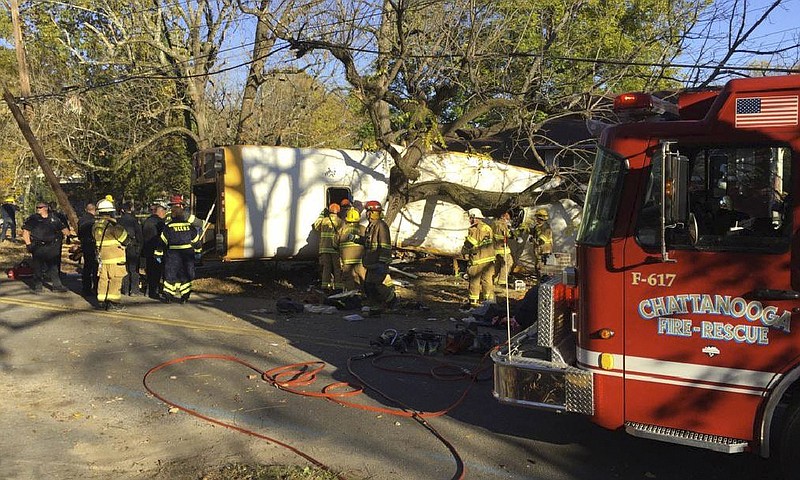 In this photo provided by the Chattanooga Fire Department via Chattanooga Times Free Press, Chattanooga Fire Department members work the scene of a fatal elementary school bus crash in Chattanooga, Tenn., Monday, Nov. 21, 2016. In a news conference Monday, Assistant Chief Tracy Arnold said there were multiple fatalities in the crash. (Bruce Garner/Chattanooga Fire Department via Chattanooga Times Free Press via AP)
            
