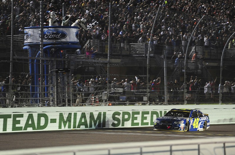 Jimmie Johnson crosses the finish line to win the NASCAR Sprint Cup auto race in Homestead, Fla., Sunday, Nov. 20, 2016. (Joe Cavaretta/South Florida Sun-Sentinel via AP)

