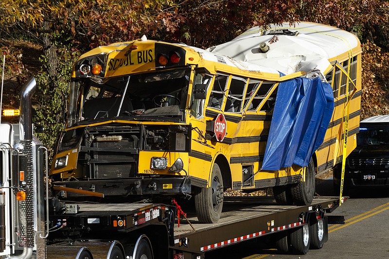 A wrecker removes the school bus from the scene of a crash on Talley Road on Tuesday, Nov. 22, 2016, in Chattanooga, Tenn. The Monday afternoon crash killed six elementary schoolchildren and injured dozens more. The NTSB has been called in to help investigate.