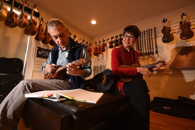 Edward Bergin, left, and Kathy Kessler play ukuleles at Mountain Music on Broad Street. Bergin and Kessler have only recently begun playing the instrument.