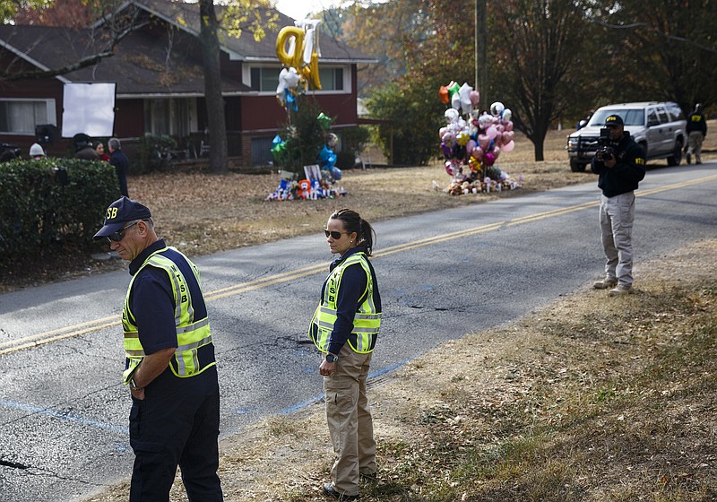 NTSB investigator in charge Robert Accetta, left, and investigator Michele Beckjord examine the road at the site of a fatal school bus crash on Talley Road on Wednesday, Nov. 23, 2016, in Chattanooga, Tenn. A makeshift memorial to victims of the Monday crash, which killed 6 Woodmore Elementary students and injured dozens more, has grown since the road was reopened Tuesday.