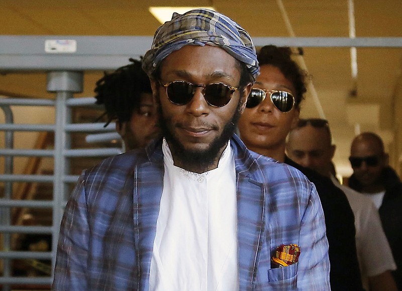 
              FILE - In this March 24, 2016 file photo, American actor and musician Yasiin Bey, also known as Mos Def, leaves the Bellville Magistrates' Court in Bellville, South Africa. Bey left South Africa on Tuesday Nov. 22, 2016, after apologizing to the government after authorities accused him of violating the country's immigration laws. In turn, authorities say, charges against him will be dropped. (AP Photo/Schalk van Zuydam, File)
            