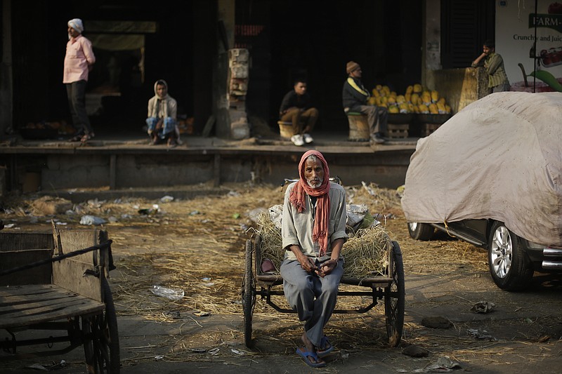 
              In this Friday, Nov. 18, 2016 photo, a laborer sits on his cart waiting for work at Azadpur Mandi, one of Asia's largest wholesale market for fruits and vegetables in New Delhi, India. Business at the massive New Delhi market is evaporating, the food spoiling and wasted, two weeks after the government's surprise currency move made more than 80 percent of India's banknotes useless. By withdrawing all 500- and 1,000-rupee notes from circulation, the government is trying to clean India's economy of "black money," or untaxed wealth. Its success remains to be seen, but for now the move has created serpentine queues outsides banks and ATMs of people replacing their rupee notes or making small withdrawals. (AP Photo/Altaf Qadri)
            