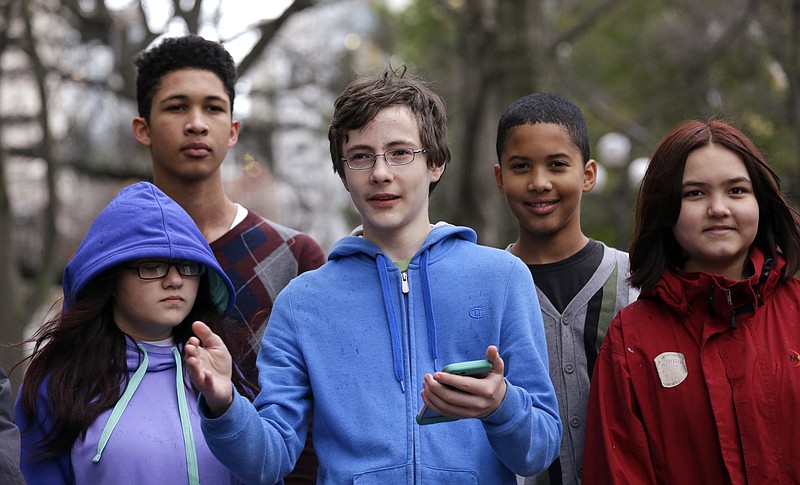 
              Petitioner Gabe Mandell, center, 14, addresses media members and supporters as he stands with other children asking a court to force state officials to adopt new rules to limit carbon emissions Tuesday, Nov. 22, 2016, in Seattle. Eight children are asking a Seattle judge to find Washington state in contempt for failing to adequately protect them and future generations from the harmful effects of climate change, part of a nationwide effort by young people to try to force action on global warming. (AP Photo/Elaine Thompson)
            