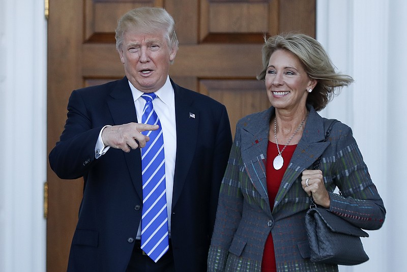 In this Nov. 19, 2016, file photo, President-elect Donald Trump and Betsy DeVos pose for photographs at Trump National Golf Club Bedminster clubhouse in Bedminster, N.J. Trump has chosen charter school advocate DeVos as Education Secretary in his administration. 