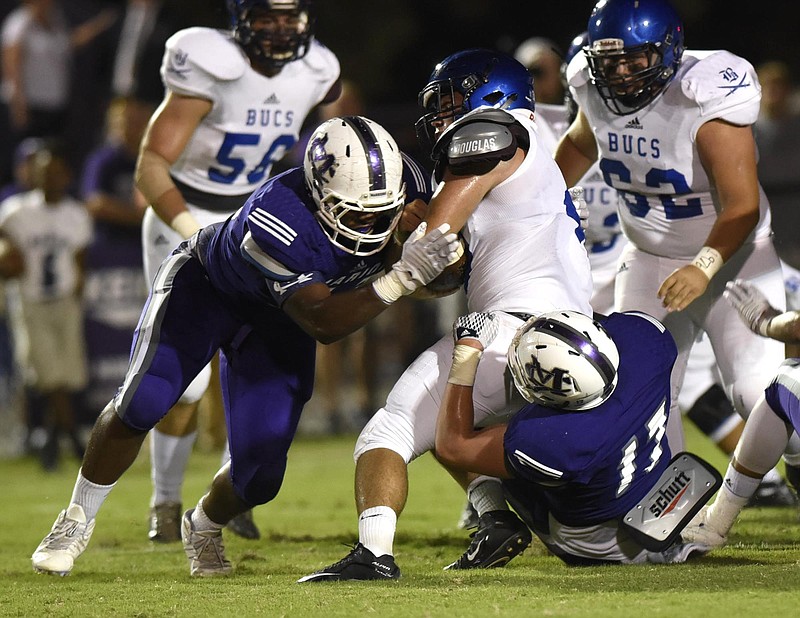 Defensive end Corey Tucker,left, has helped linebacker Alex Kirkendoll (17) and Marion County play stingy defense in advancing again to a Class 2A state football semifinal.