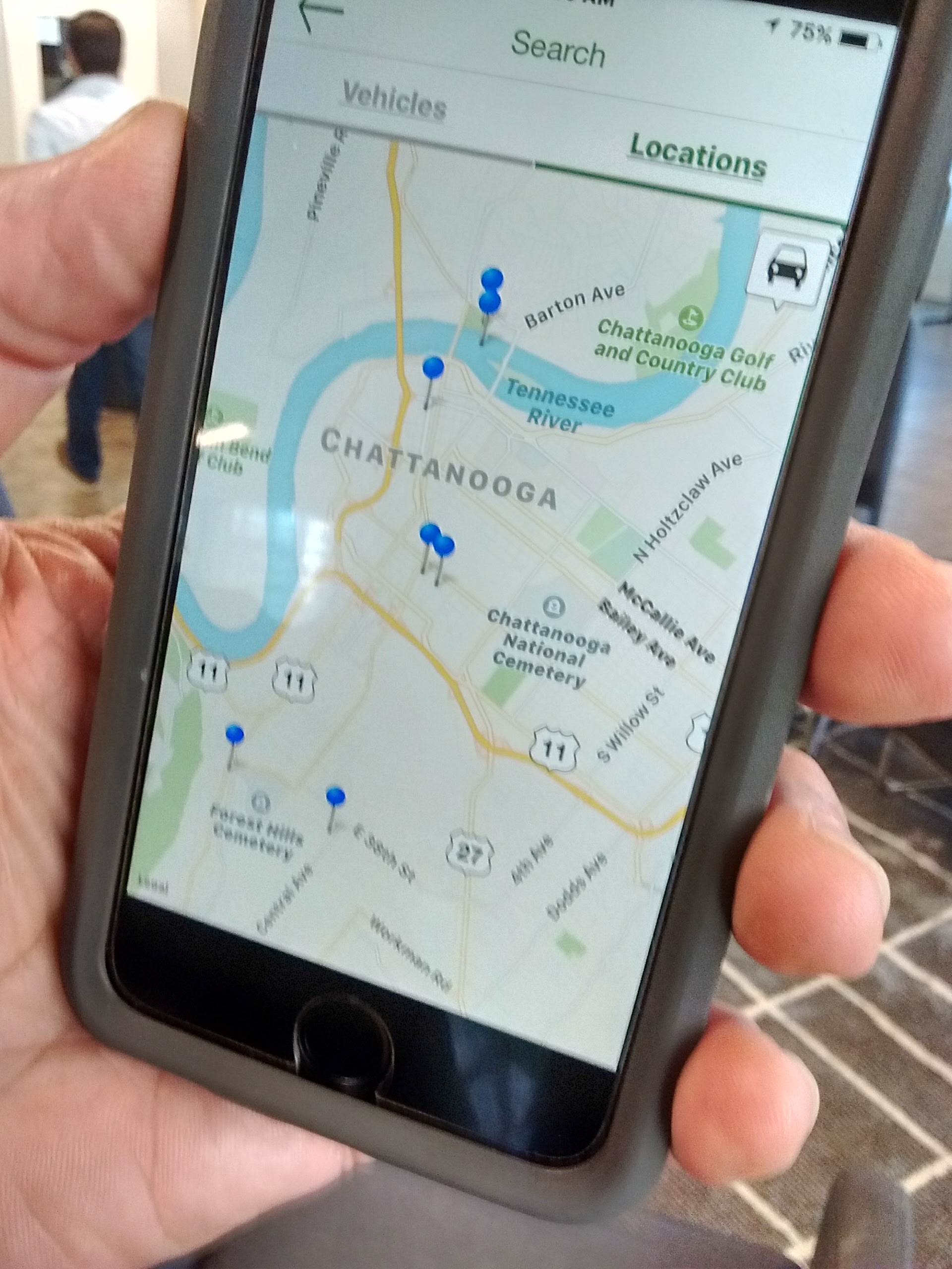Longtime Chattanooga electric car advocate Jim Frierson shows the smartphone app used to find and unlock Green Commuter Chattanooga's $9-an-hour Nissan Leafs.
