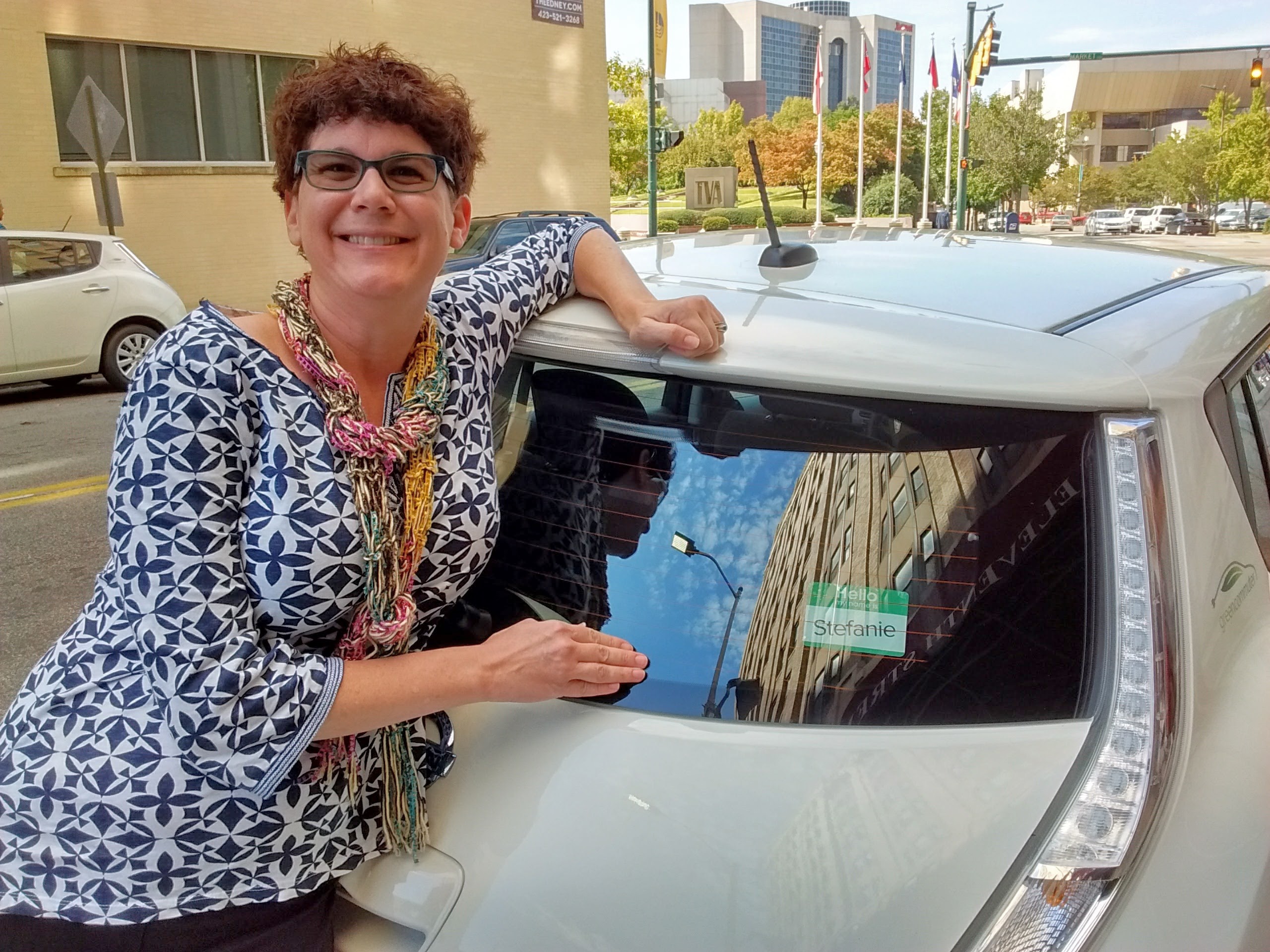 Stefanie deOlloqui, principal consultant for Chattanooga-based Prova Group LLC, which helped set up Green Commute Chattanooga and also designed and deployed the city's Bike Chattanooga bicycle-sharing program, stand near a Nissan Leaf named Stefanie after her.