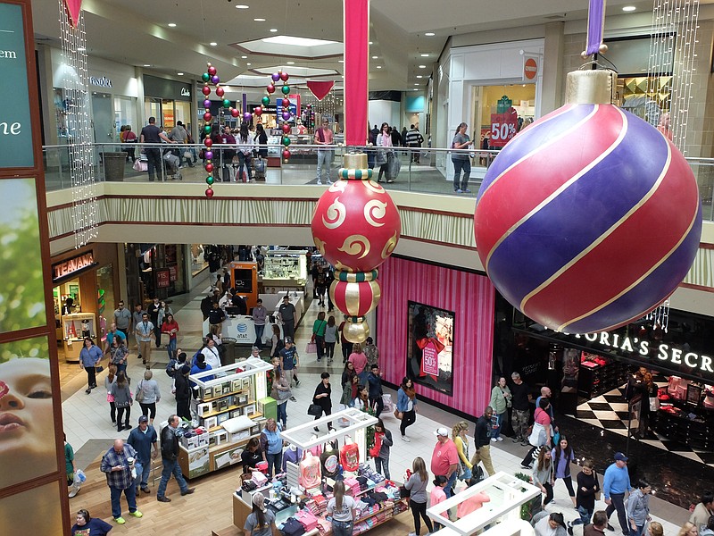 Large Christmas decorations hang inside Hamilton Place Mall as shoppers take advantage of Black Friday sales.