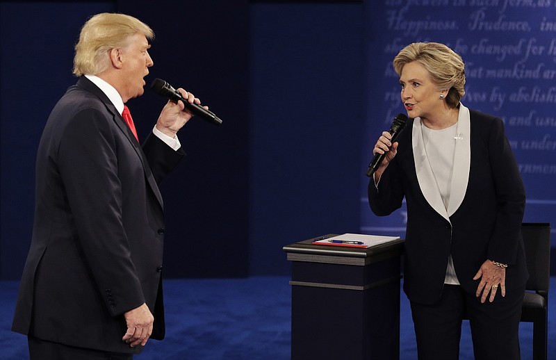 
              FILE - In this Sunday, Oct. 9, 2016, file photo, Republican presidential nominee Donald Trump and Democratic presidential nominee Hillary Clinton speak during the second presidential debate at Washington University in St. Louis. A "sophisticated" Russian propaganda campaign helped flood social media with fake news stories during the election season, according to a new report in The Washington Post. The Post says the goal was to punish Hillary Clinton, help Donald Trump, and undermine faith in American democracy. (AP Photo/John Locher, File)
            