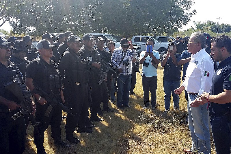 
              In this photo released by Guerrero state Attorney Generals Office, Javier Olea, attorney general of Guerrero state, right, talks to police at the start of a security operation in San Jeronimo El Grande, Mexico, Thursday, Nov. 24, 2016.  Soldiers and police fanned out Friday across Guerrero state, chasing a wounded gang leader and trying to quell a wave of violence that included the discovery of hidden graves holding dozens of bodies and a camp where gunmen stored the severed heads of nine rivals in a cooler. (Guerrero state Attorney Generals Office via AP)
            