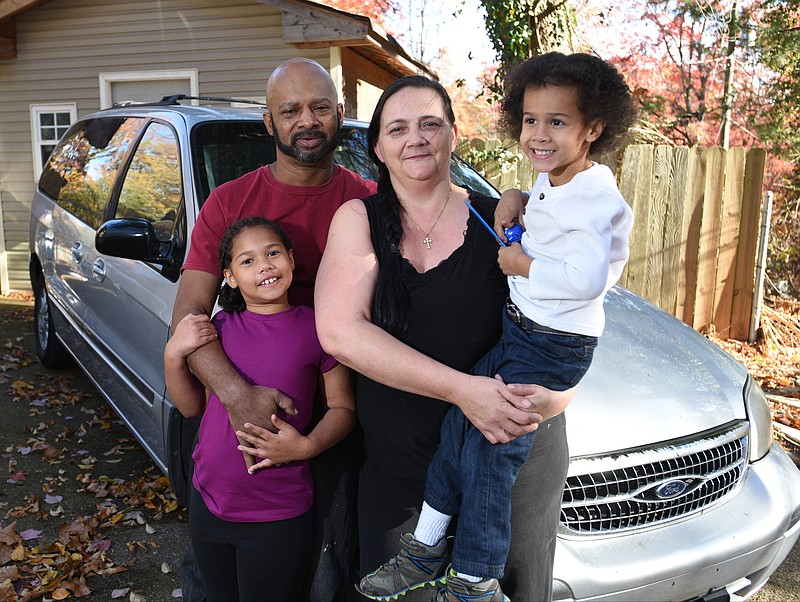 Bradley and Shannon Taylor stand with kids Elizabeth, standing, and Aiden stand Wednesday, Nov. 23, 2016 with their van.