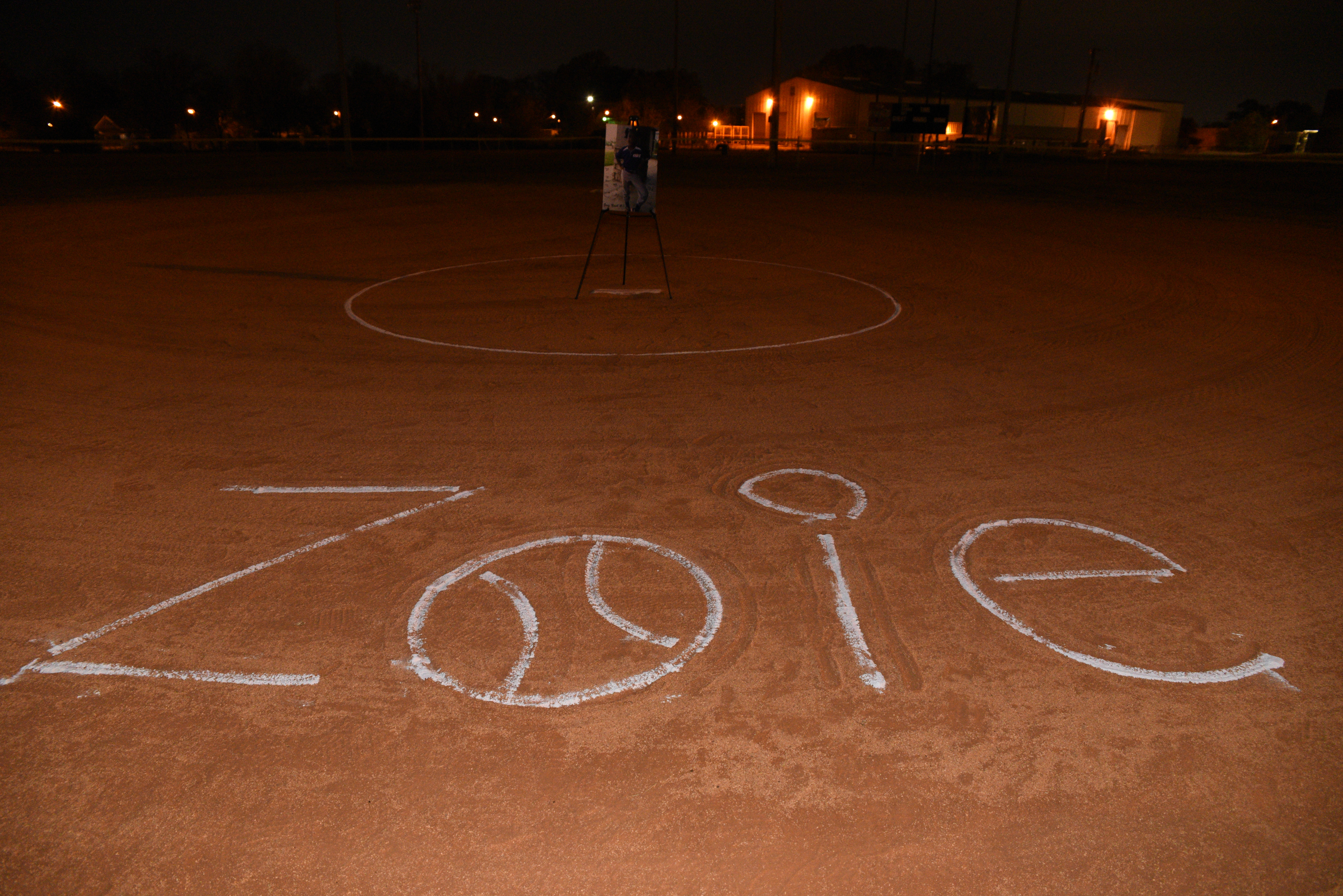 The name Zoie is chalked onto the softball field Wednesday, Nov. 23, 2016, at East Lake Recreation Center. Several people gathered to memorialize Zoie Nash, who was killed in a bus crash this week.