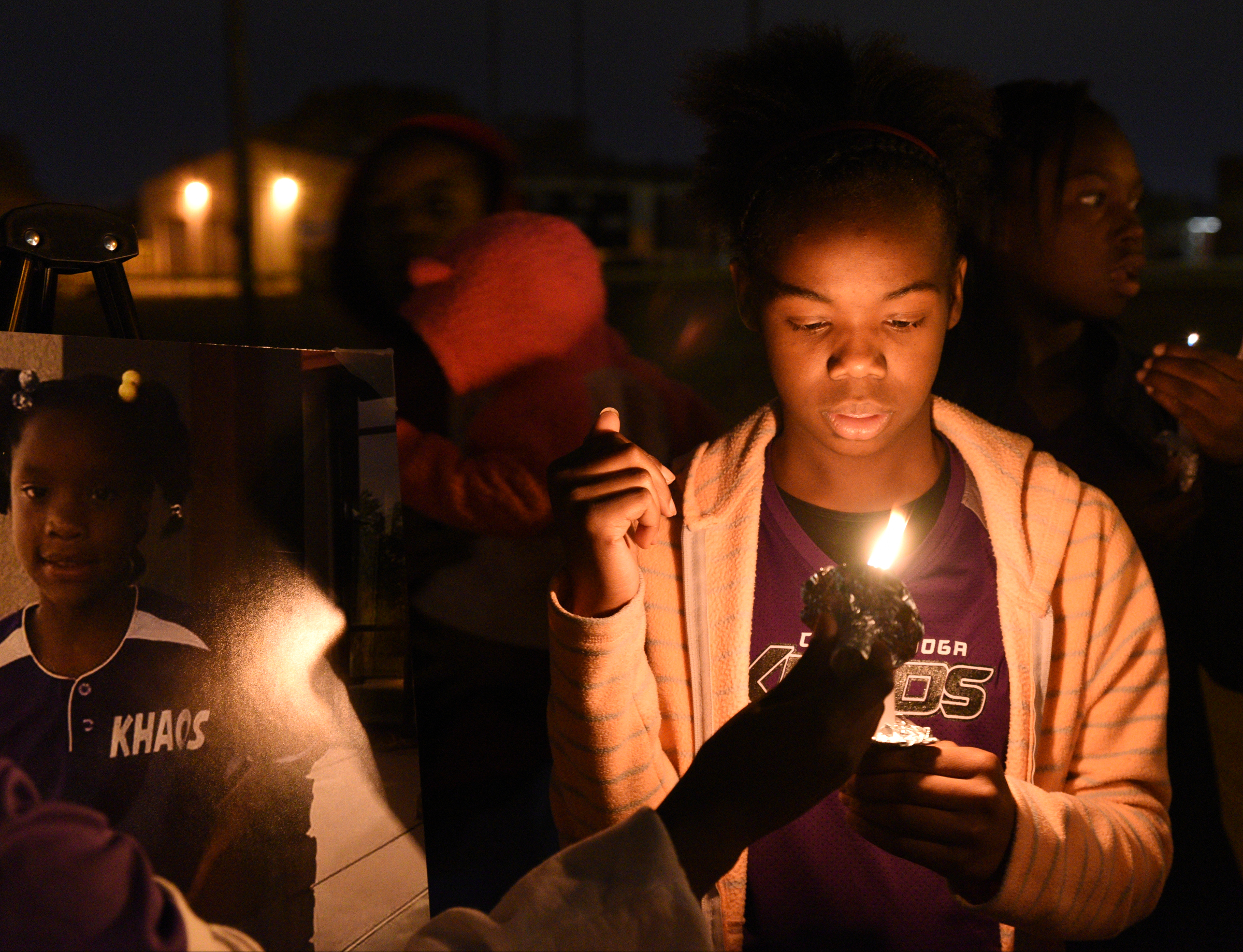 Tenahiya Davis holds a candle Wednesday, Nov. 23, 2016, at East Lake Recreation Center. Several people gathered to memorialize Zoie Nash, who was killed in a bus crash this week.