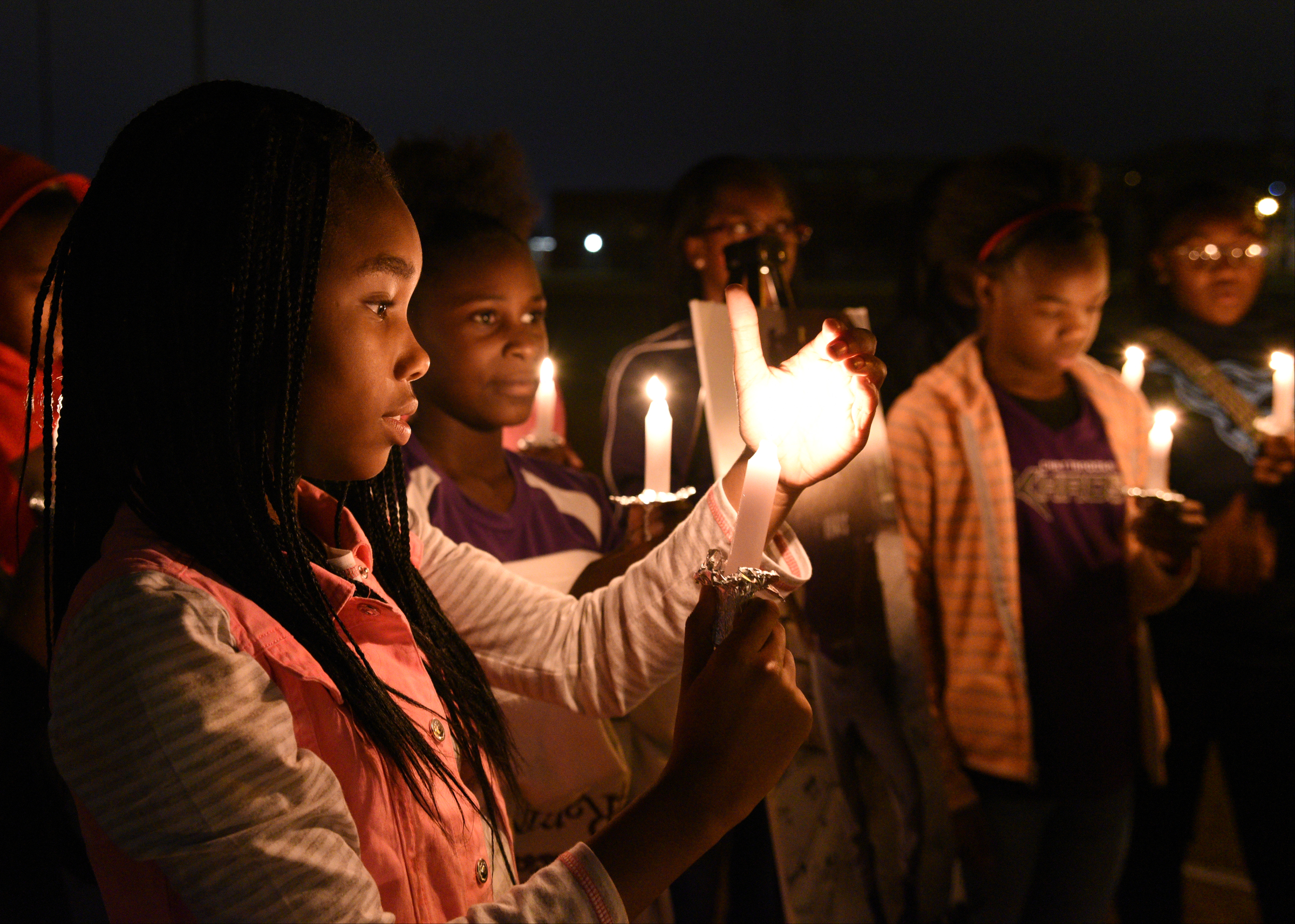 Ma'Liyah Montgomery, left, holds a candle Wednesday, Nov. 23, 2016, at East Lake Recreation Center. Several people gathered to memorialize Zoie Nash, who was killed in a bus crash this week.