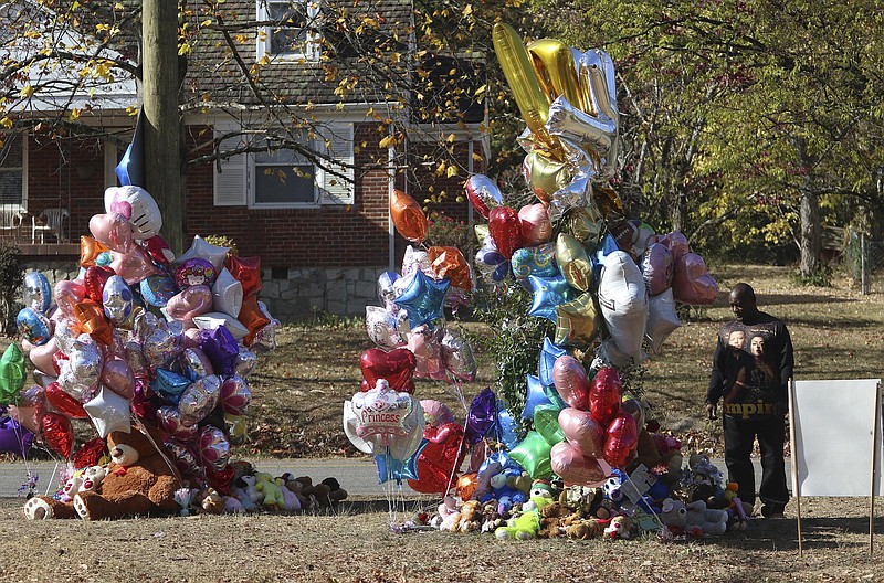 Staff Photo by Dan Henry / The Chattanooga Times Free Press- 11/24/16. Michael Frye visits a memorial of teddy bears, mementos, and balloons placed at the site of a fatal school bus crash on Talley Road on Thursday, Nov. 24, 2016, in Chattanooga, Tenn. The memorial to victims of the Monday crash, which killed 6 Woodmore Elementary students and injured dozens more, has grown since the road was reopened Tuesday.