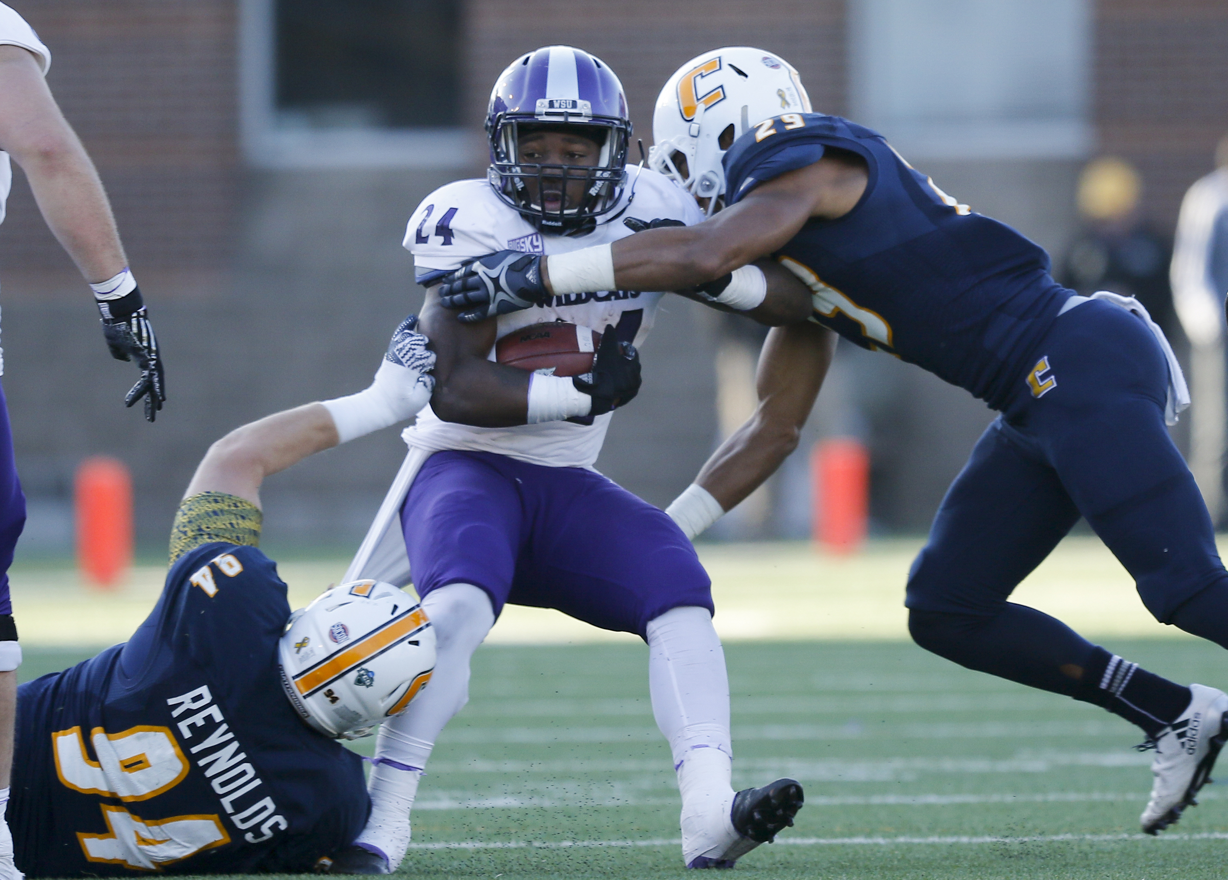 UTC defensive lineman Taylor Reynolds (94) and defensive back Lucas Webb (29) tackle Weber State running back Emmanuel Pooler during the Mocs' first-round FCS football playoff game against Weber State at Finely Stadium on Saturday, Nov. 26, 2016, in Chattanooga, Tenn. UTC won 45-14.