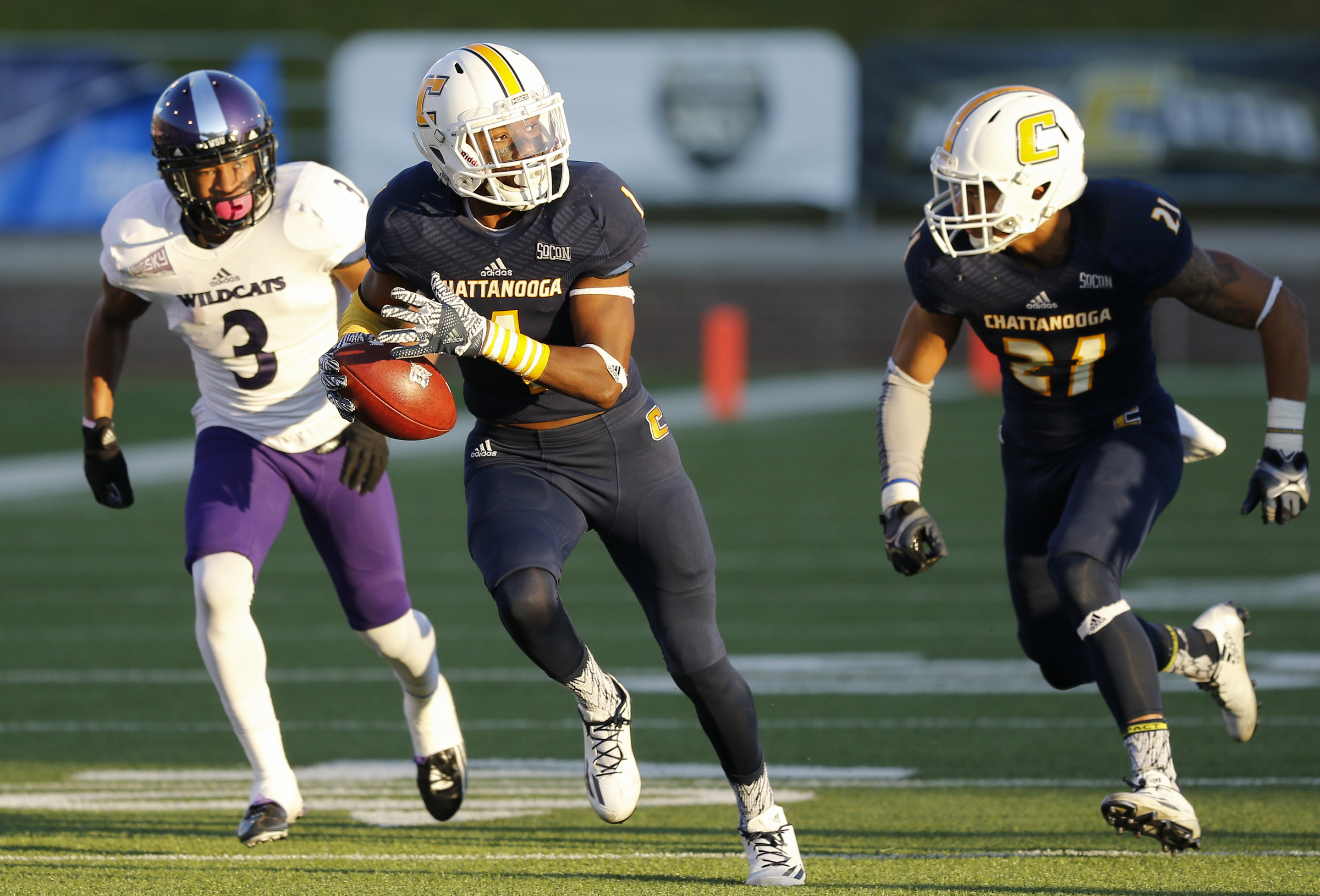UTC defensive back Trevor Wright, center, returns an interception around Weber State wide receiver Darryl Denby (3) during the Mocs' first-round FCS football playoff game against Weber State at Finely Stadium on Saturday, Nov. 26, 2016, in Chattanooga, Tenn. UTC won 45-14.