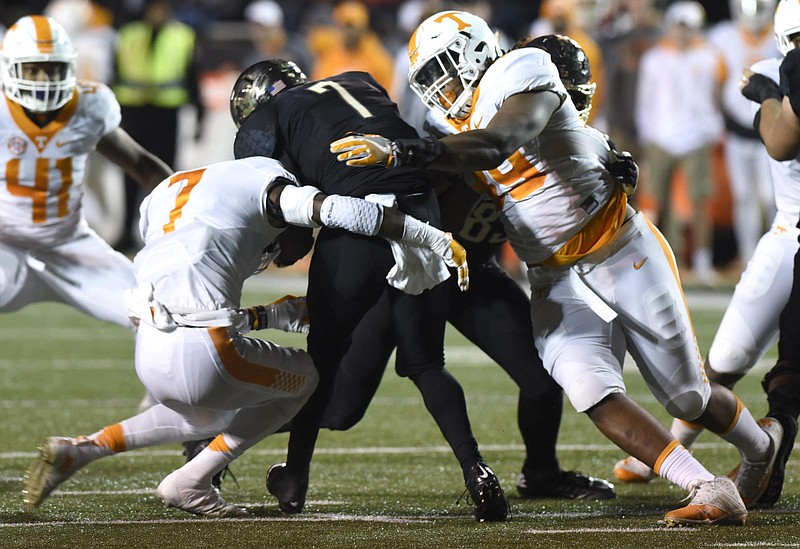 Tennessee's Rashaan Gaulden (7) and Kendal Vickers stop Vanderbilt's Ralph Webb (7) for a loss Saturday night.