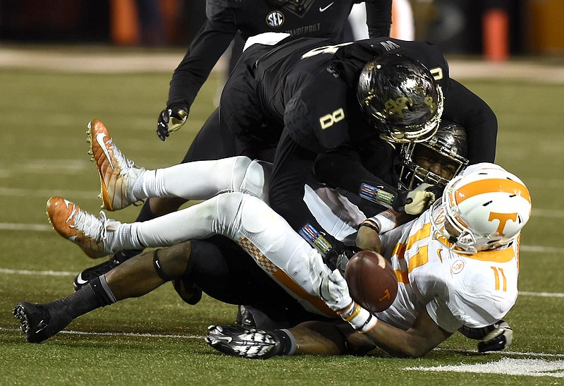 Tennessee quarterback Joshua Dobbs (11) fumbles as he is tackled by Vanderbilt's Zach Cunningham (41) and Joejuan Williams (8).  Vanderbilt recovered the ball. The turnover was a turning point in the game.  The Tennessee Volunteers visited the Vanderbilt Commodores in a cross-state rivalry at Dudley Stadium on November 26, 2016.  
