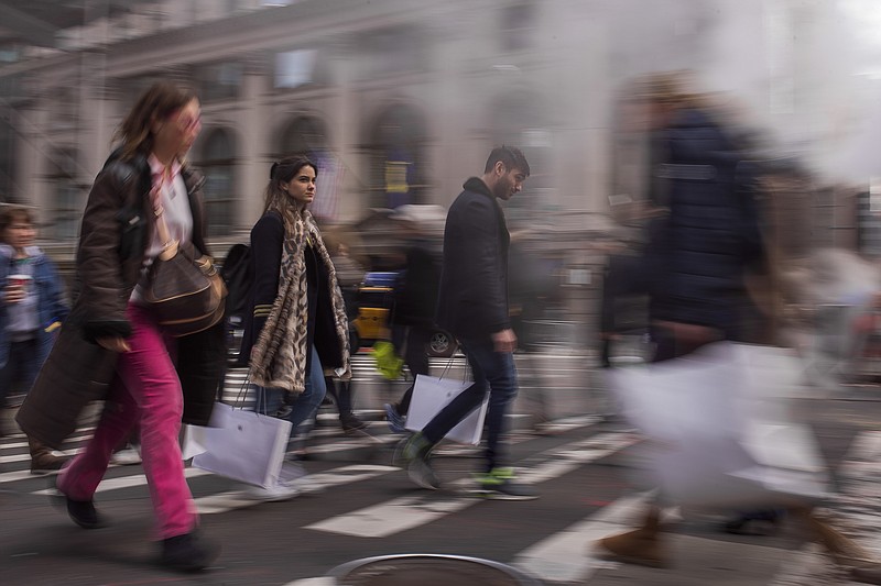 
              Shoppers carry their purchases as they walk though the steam coming from the underground along Fifth Avenue on Black Friday in New York, Friday, Nov. 25, 2016. Shoppers were on the hunt for deals and were at the stores for entertainment Friday as malls opened for what is still one of the busiest days of the year, even as the start of the holiday season edges ever earlier. (AP Photo/Andres Kudacki)
            