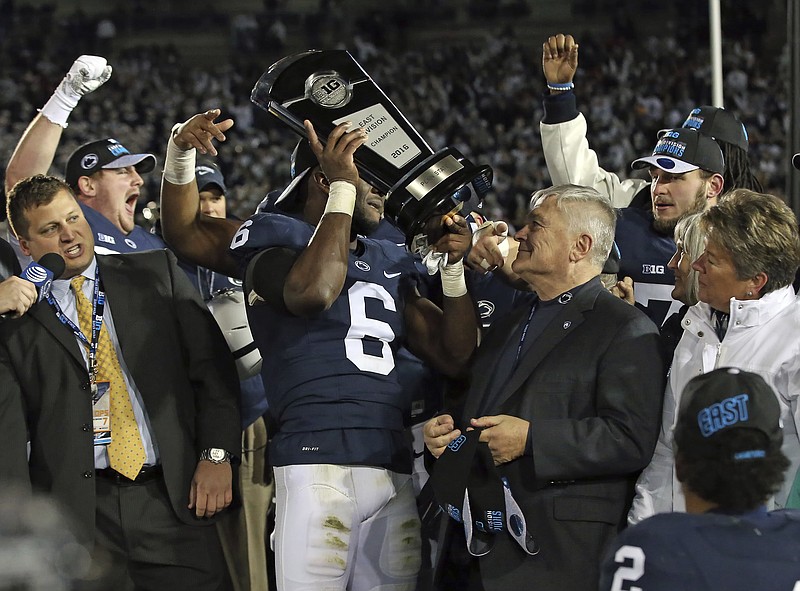 
              Penn State's Malik Golden (6) hoists the Big Ten East division trophy after defeating Michigan State 45-12 in an NCAA college football game in State College, Pa., Saturday Nov. 26, 2016. (AP Photo/Chris Knight)
            