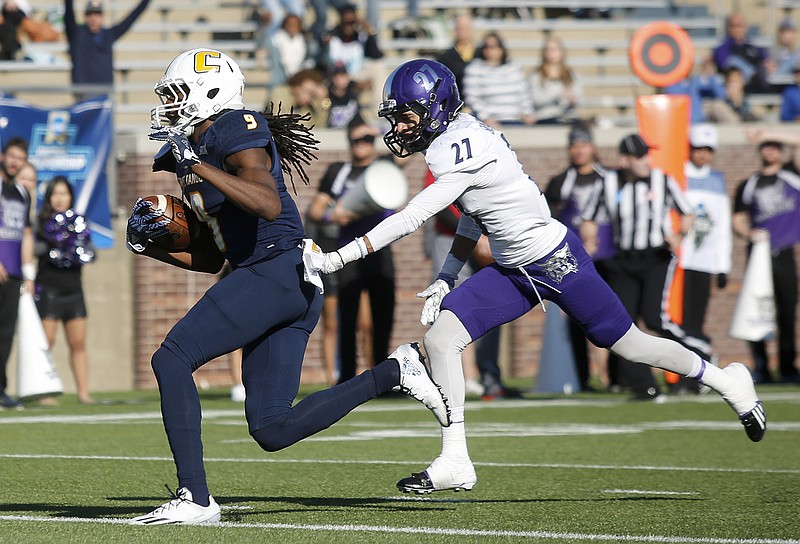 UTC wide receiver Alphonso Stewart heads toward the end zone with Weber State cornerback Dre Snowden trailing during the Mocs' 45-14 win in the first round of the FCS playoffs Saturday at Finley Stadium.
