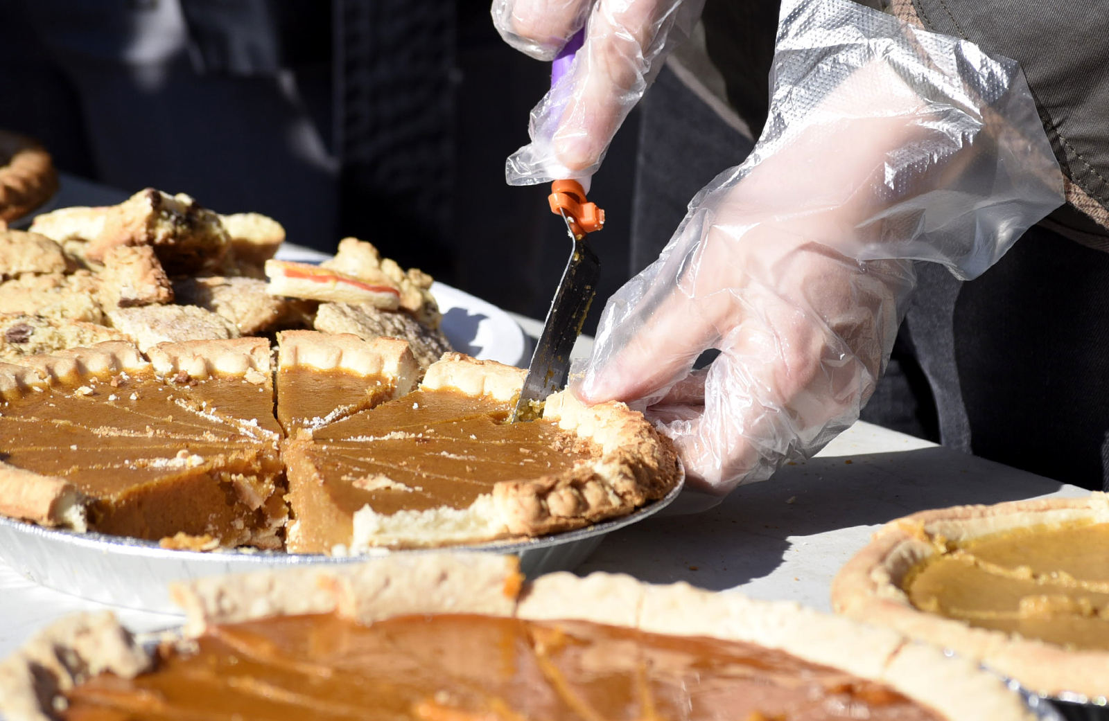 Dozens of pumpkin pies are served to the crowd.