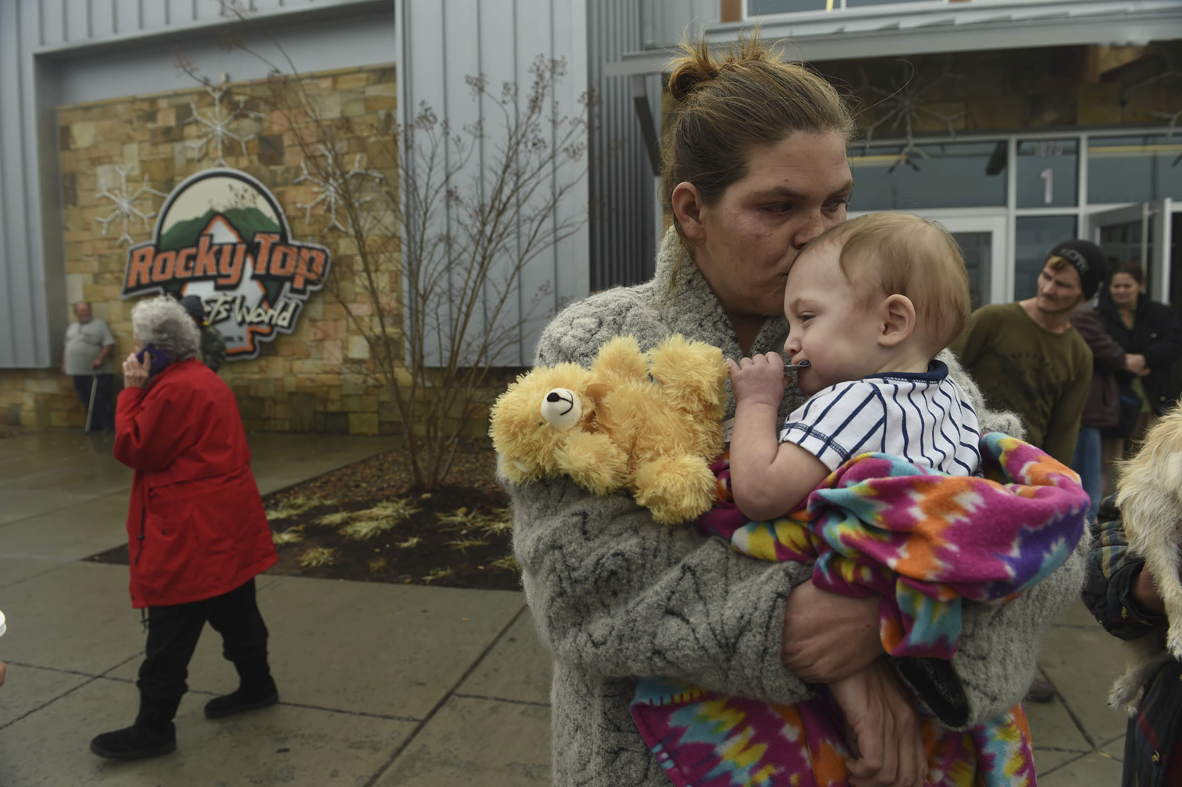 Shari Deason holds her ld son William outside of the Rocky Top Sports Center, serving as a Red Cross shelter, next door to the TEMA command center at Gatlinburg-Pittman High School in Gatlinburg, Tenn., Tuesday, Nov. 29, 2016. More than 2000 people have checked in to various shelters. (Amy Smotherman Burgess/Knoxville News Sentinel via AP)