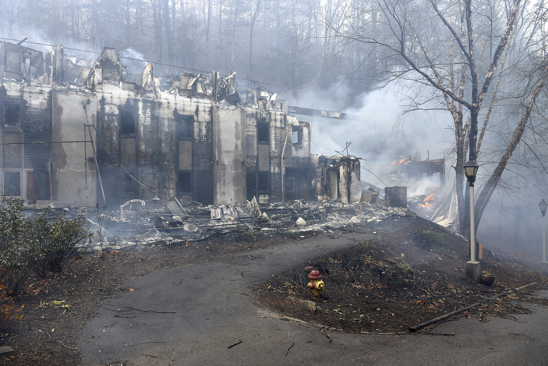 Two of the dormitories at Arrowmont School are damaged from the wildfires around Gatlinburg, Tenn., on Tuesday, Nov. 29, 2016. Rain had begun to fall in some areas, but experts predicted it would not be enough to end the relentless drought that has spread across several Southern states and provided fuel for fires now burning for weeks in states including Tennessee, Georgia and North Carolina. (Michael Patrick/Knoxville News Sentinel via AP)