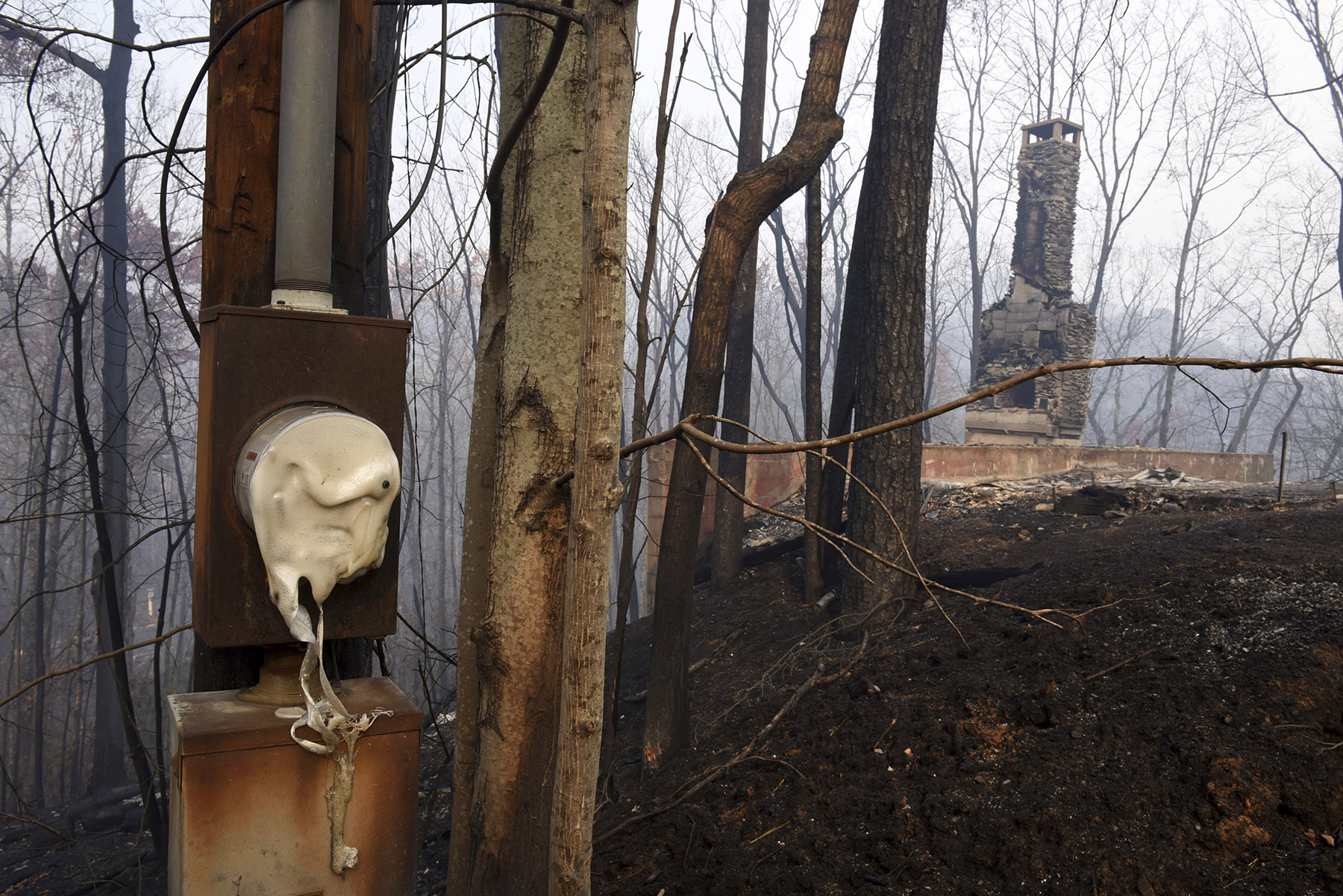 Chimneys and melted electrical boxes were damaged from the wildfires around Gatlinburg, Tenn., on Tuesday, Nov. 29, 2016. Rain had begun to fall in some areas, but experts predicted it would not be enough to end the relentless drought that has spread across several Southern states and provided fuel for fires now burning for weeks in states including Tennessee, Georgia and North Carolina. (Michael Patrick/Knoxville News Sentinel via AP)